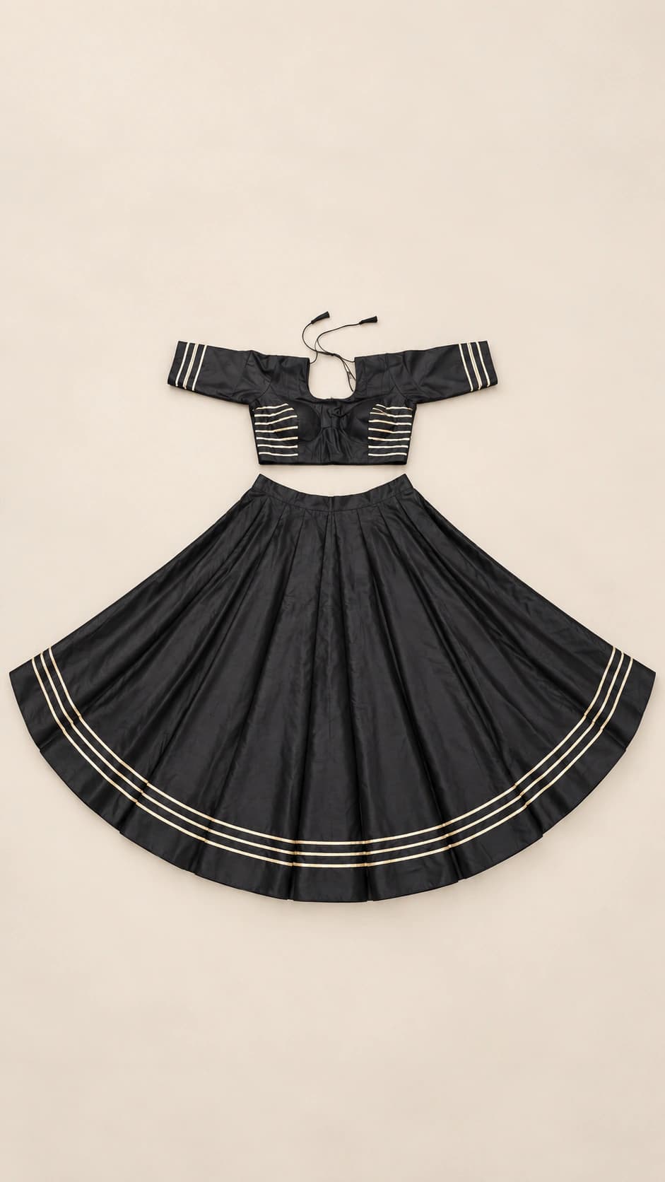 Midnight Grace: A minimal black lehenga set shaped by crisp horizontal metallic lines and a streamlined off-shoulder-style blouse silhouette.