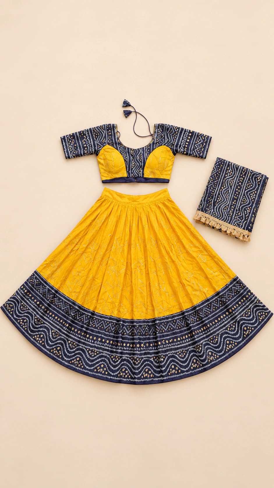 Saffron Beat: A warm marigold lehenga grounded by an indigo folk-pattern border and a colour-block blouse with patterned short sleeves.
