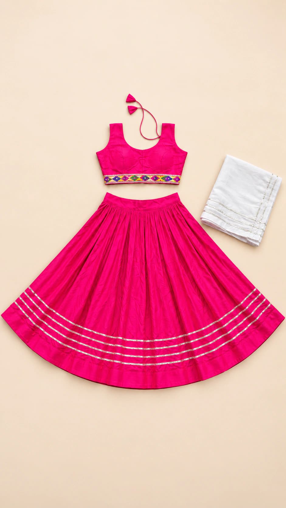Pink Sparkle: A vibrant hot-pink lehenga with a neat sleeveless blouse, decorative waistband and crisp silver-toned lines at the hem.