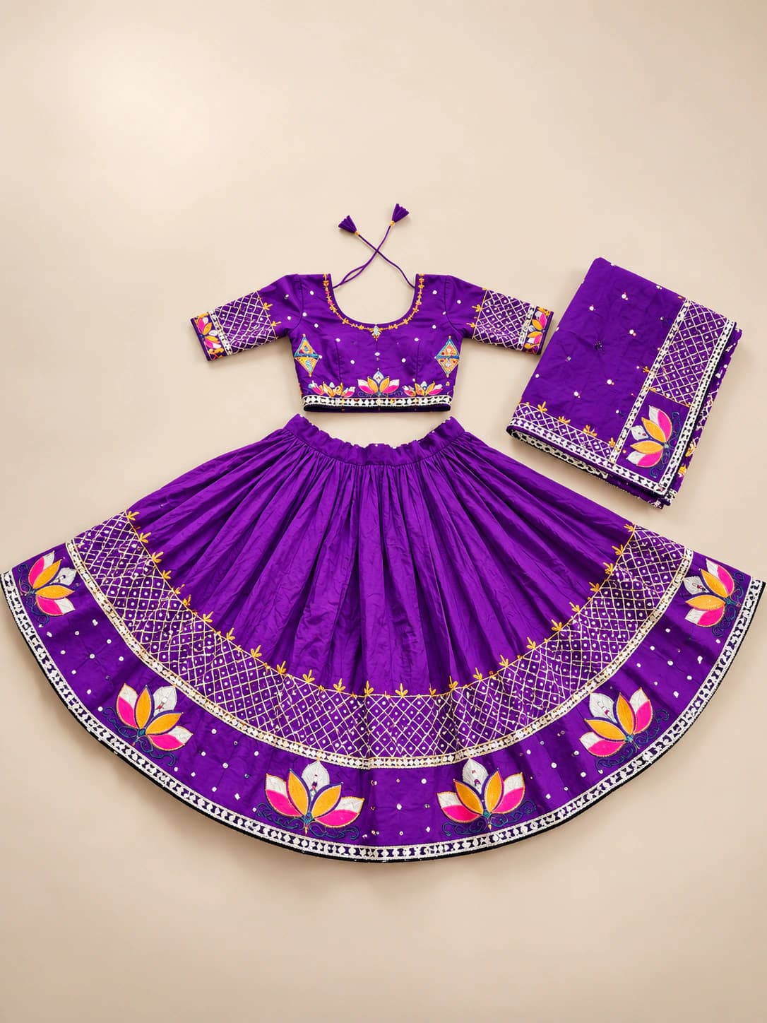 Royal Violet: A deep violet set with a decorated blouse and an elaborate lower border of bright lotus-like motifs, dotted bands and metallic-toned details.