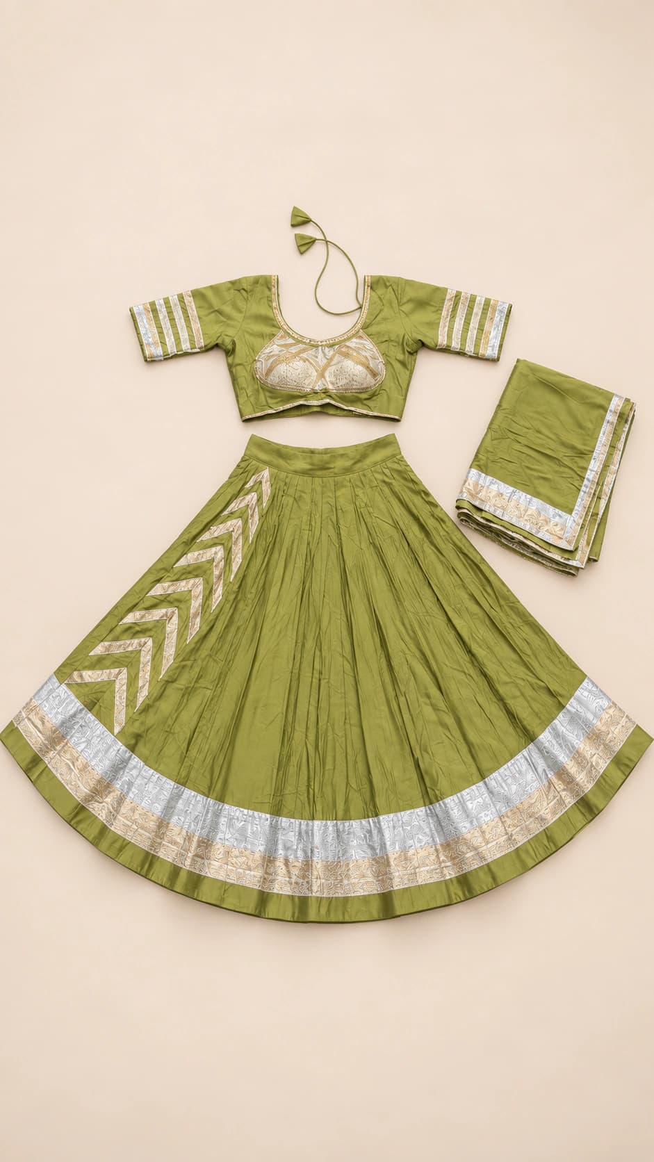 Sage Chevron: A soft sage-green lehenga with bold chevron accents, metallic-looking silver borders and a delicately styled short-sleeve blouse.